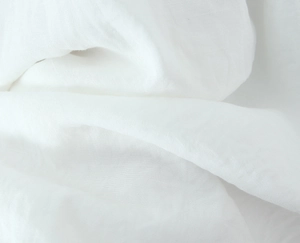 Dettaglio macro del tessuto bianco con trama naturale in lino e trama del vestito