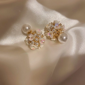 Détails des boucles d'oreilles florales avec pétales nacrés et perles sur soie