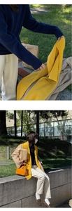 Detail showing the vertical ribbed texture of a soft yellow knitted scarf for autumn