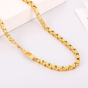 Dettaglio ravvicinato di collana in titanio dorato con maglie a forma di fiori a cinque petali