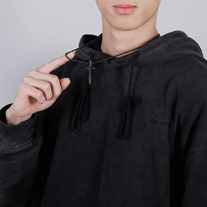 Détail d'un collier hip-hop avec pendentif épée noire porté par un mannequin homme