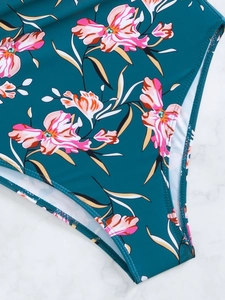Close-up of floral pattern and high-quality stitching on dark teal swimsuit fabric