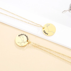 Detail of gold constellation pendants featuring Aries and Sagittarius engraved designs