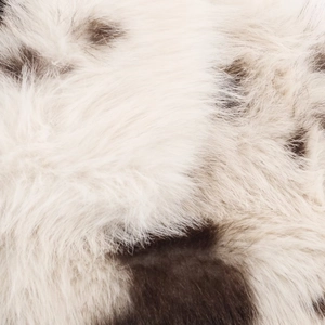 Vue macro montrant la texture douce de la fausse fourrure blanche à taches contrastées
