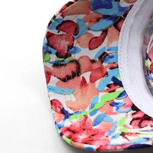 Detail of colorful floral tie-dye cotton baseball cap with gold embroidery and premium stitching