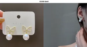 Close-up of golden butterfly earrings with sparkling cubic zirconia and dangling white pearls