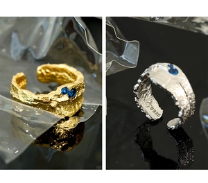 Macro shot of S925 silver rings with irregular lava texture and blue zircon details