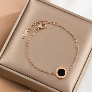 Rose gold stainless steel bracelet with black circular pendant and Roman numerals