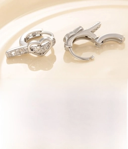 Detail showing heart buckle earrings in silver copper with sparkling zircon inlays