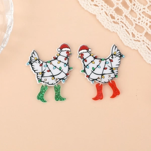Close-up of festive acrylic white chicken earrings with Christmas hats and glitter boots