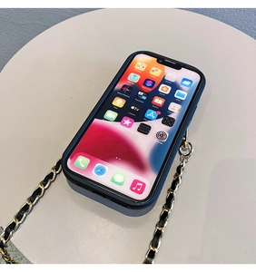 Detail of iPhone case featuring black leather woven with golden metal chain strap