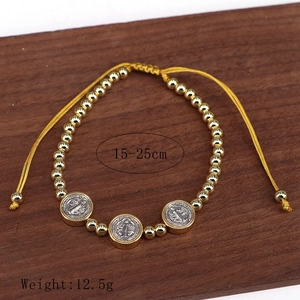 Golden beaded bracelet with religious Saint Benedict medals and adjustable yellow cord