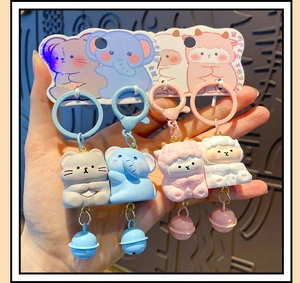 Close-up of cute cartoon resin animal keychains with bells and magnetic CP couple design