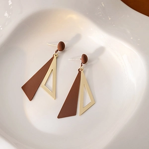 Detail of geometric earrings featuring brown matte and gold hollow triangular pendants