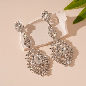 Boucles d'oreilles pendantes argentées avec cristaux sur décor de pierre blanche