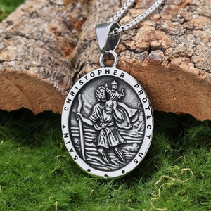 Macro shot of silver Saint Christopher pendant on natural wood and moss background