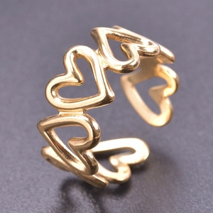 Macro detail of gold-plated open ring featuring a continuous hollow heart pattern design