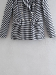 Detailansicht der silbernen Löwenkopf-Knöpfe auf einem Tweed-Blazer mit Hahnentrittmuster