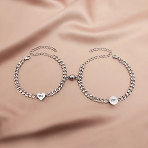 Close-up of magnetic Cuban link bracelets with engraved heart and round metal tags