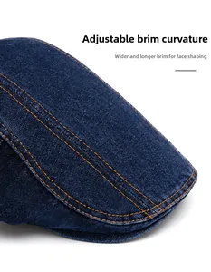 Detailed close-up of dark denim cap featuring orange stitching and adjustable wide brim