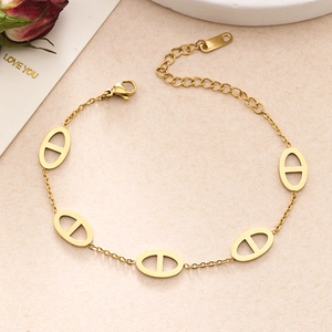 Macro detail of gold-plated anchor chain bracelet with adjustable clasp and dry flowers