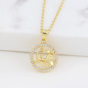 Macro detail of gold zodiac pendant with trident figure and sparkling crystal bezel