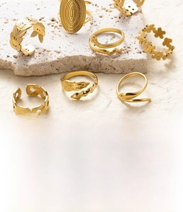 Detail showing a set of gold titanium steel rings with snake, feather and floral motifs