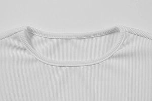 Détail du décolleté de la robe en maille côtelée blanche avec coutures précises et texture