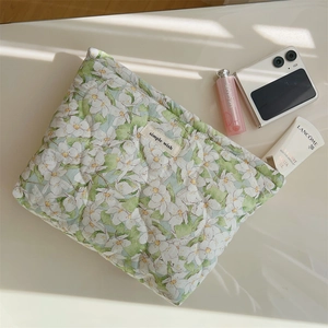 Detail of floral quilted cotton makeup bag featuring soft texture and simple wish label