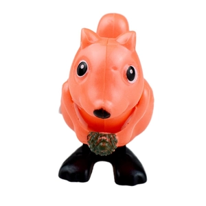 Funny orange wind-up jumping squirrel toy holding a pinecone on white background
