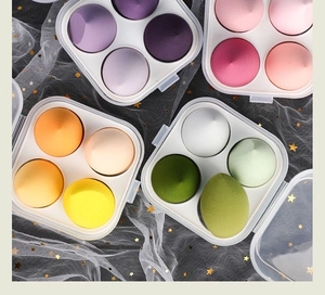 Flat lay of colorful makeup sponge sets in transparent boxes on star tulle background