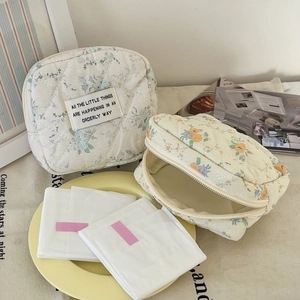 Quilted floral makeup bags in blue and yellow patterns with zipper closure