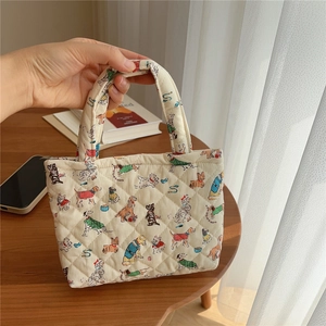 Close-up of quilted cotton phone bag featuring cute cartoon dog patterns and zipper