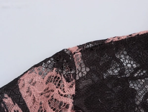 Macro view showing intricate floral lace patterns in black and pink fabric textures