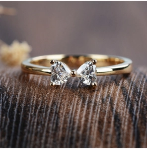 Close-up of bow-shaped S925 silver ring with heart-cut zircons and 18k gold plating