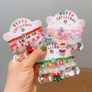 Handmade Christmas beaded bracelet set with Santa, reindeer, and tree charms on festive cards