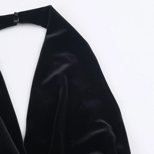 Dettaglio dello scollo all'americana in velluto nero con texture e bottone posteriore