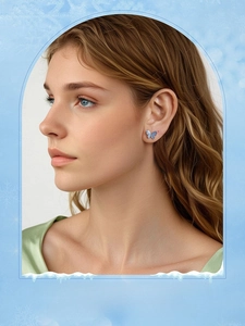Detailed close-up of blue butterfly stud earrings in s925 silver on a female model
