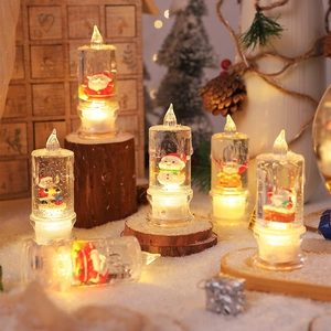 LED Christmas liquid glitter candles with Santa and snowman figures, warm glowing light