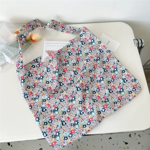 Detail of floral canvas shoulder bag showing soft fabric texture and colorful patterns