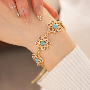 Detail of vintage gold flower bracelet with blue turquoise and sparkling rhinestones
