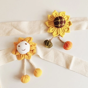 Detail of floral fabric sunflower curtain tiebacks for kids rooms in warm yellow tones