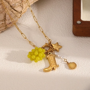 Detail of 18k gold chain necklace with grape, boot, star, pearl and shell charms