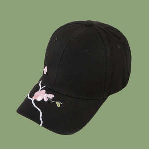 Detailed pink floral plum blossom embroidery on a black cotton baseball cap side