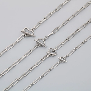 Detailed close-up of silver paperclip chain necklace with heart and circle toggle clasps