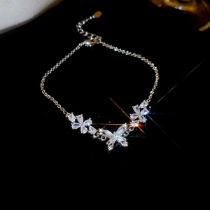 Close-up of silver-plated flower and butterfly bracelet with sparkling zircon stones