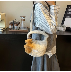 Gros plan du sac seau en polaire beige avec pendentif ours en peluche et logo CLEARVK