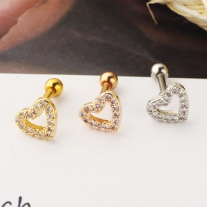 Macro shot of heart-shaped cartilage piercings in gold, silver, and rose gold with zircon