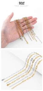 Close-up of gold and silver paperclip chain necklaces with lobster clasp and extender
