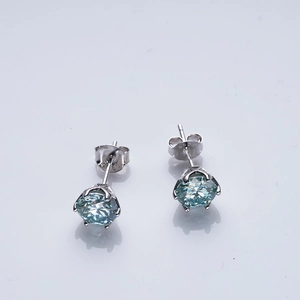 Macro shot of S925 silver stud earrings featuring round cut light blue gemstones
